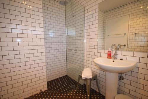 a white bathroom with a sink and a mirror at Carawatha in Blackheath