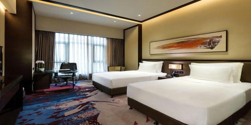 a hotel room with two beds and a desk at Crowne Plaza Chongqing New North Zone by IHG in Chongqing