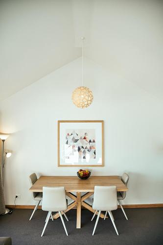 a dining room with a wooden table and white chairs at Salamanca Inn in Hobart