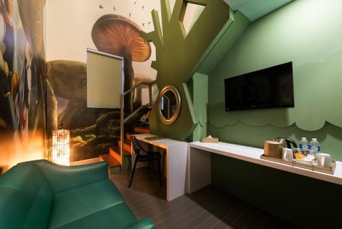 um quarto com uma parede verde, uma secretária e uma televisão em Maison Boutique Theme Hotel Kuala Lumpur by Swing & Pillows em Kuala Lumpur
