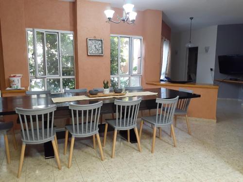a kitchen with a dining room table and chairs at וילה בת גליל יסוד המעלה in Yesod Hamaala