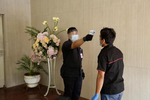 two men taking a picture of a bouquet of flowers at Ambhara Hotel in Jakarta
