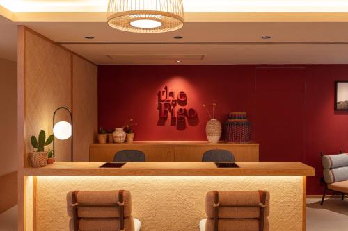 a lobby with a reception desk with a red wall at the Figo in Hong Kong