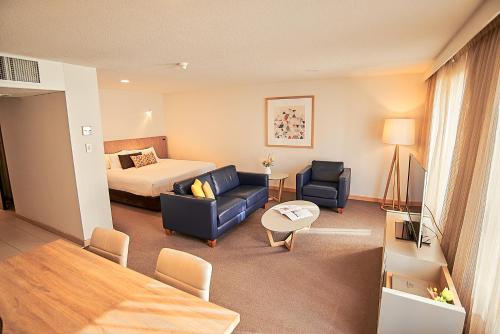 a hotel room with a bed and a living room at Salamanca Inn in Hobart