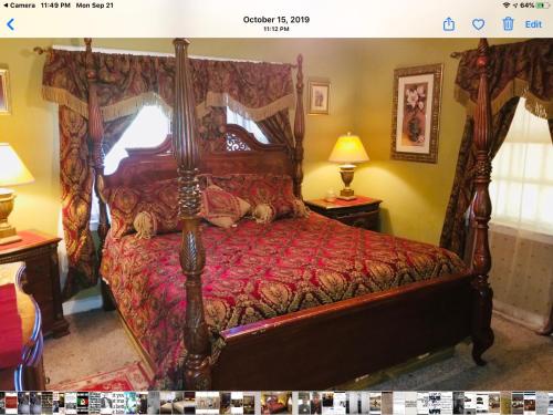 a bedroom with a large bed with a red comforter at 3 BEDROOM SLEEPs 8 NICE SPACIOUS APARTMENT B 89 in Montgomery