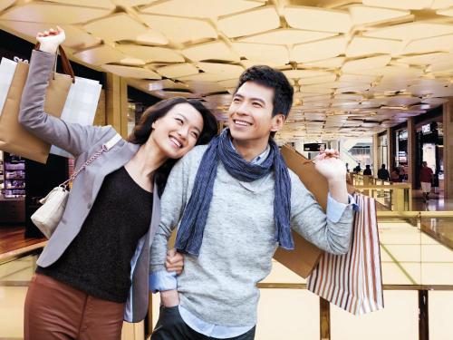 a man and woman holding shopping bags in a store at Resorts World Genting - First World Hotel in Genting Highlands