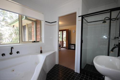 a bathroom with a bath tub and a sink at Highland View in Mount Victoria