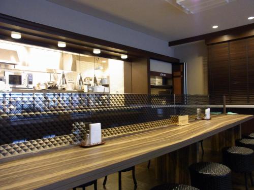a bar in a restaurant with chairs and a counter at Tsuruga Manten Hotel Ekimae in Tsuruga