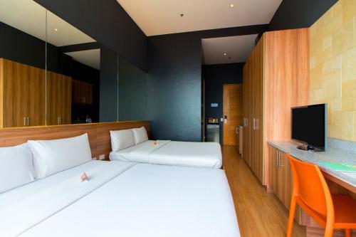 a hotel room with two beds and a television at Azumi Boutique Hotel in Manila