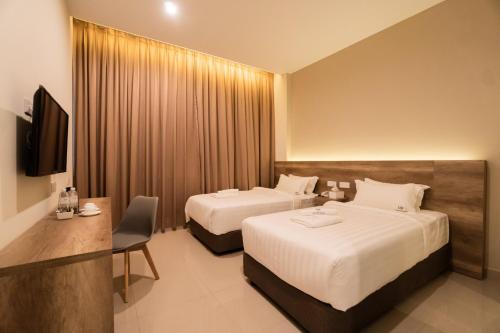 a hotel room with two beds and a desk at D&F BOUTIQUE HOTEL SEREMBAN 2 in Seremban