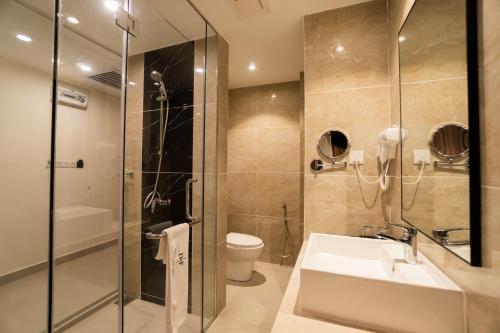 a bathroom with a sink and a shower and a toilet at D&F BOUTIQUE HOTEL SEREMBAN 2 in Seremban