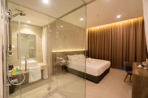 bagno con letto e doccia in vetro di D&F BOUTIQUE HOTEL SEREMBAN 2 a Seremban