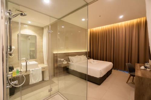 uma casa de banho com uma cama e uma cabina de duche em vidro em D&F BOUTIQUE HOTEL SEREMBAN 2 em Seremban