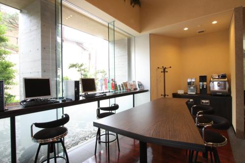 a conference room with a table and chairs and a window at Uozu Manten Hotel Ekimae in Uozu
