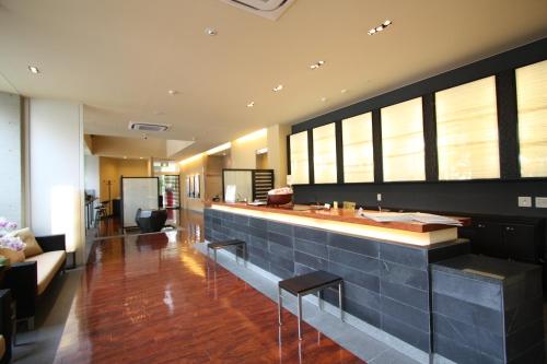 a lobby with a bar with benches and a couch at Uozu Manten Hotel Ekimae in Uozu