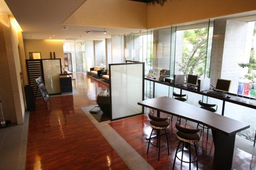 a room with a bar with chairs and a table at Uozu Manten Hotel Ekimae in Uozu