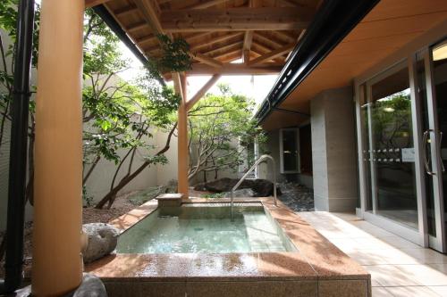 a hot tub in the middle of a house at Uozu Manten Hotel Ekimae in Uozu