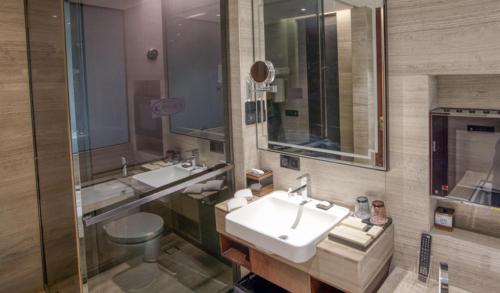 a bathroom with two sinks and a toilet at Yantai Meiya International ApartHotel (Previous Ramada Plaza) in Yantai