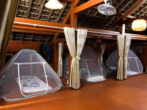 three domed tents on a wooden table with curtains at Pài Bjooc homestay in Làng Mán