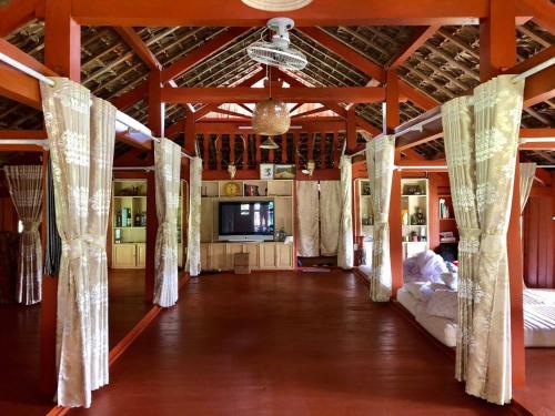 una habitación con camas y cortinas en un edificio en Pài Bjooc homestay en Làng Mán