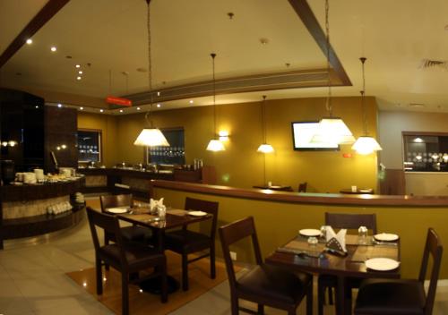 a restaurant with tables and chairs and a bar at Ginger Guwahati in Guwahati