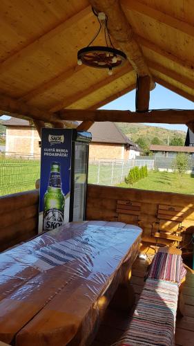 a bottle of beer sitting on a bench under a roof at Casa Alesia Bucovina in Gura Humorului