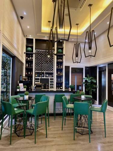 a restaurant with green chairs and tables and a bar at Azumi Boutique Hotel in Manila
