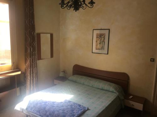 Habitación pequeña con cama y ventana en Antica Sartoria, en Palermo