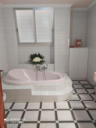 a bathroom with a bath tub with a window at Casa MarTa in Chella