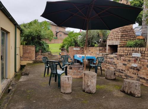 a patio with a table and chairs and an umbrella at Guesthouse 914 in Sabie