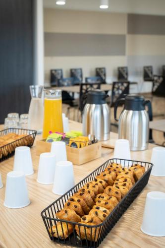 a table with a tray of breads in a basket at La Résidence du Parc d'Olhain in Maisnil-lès-Ruitz