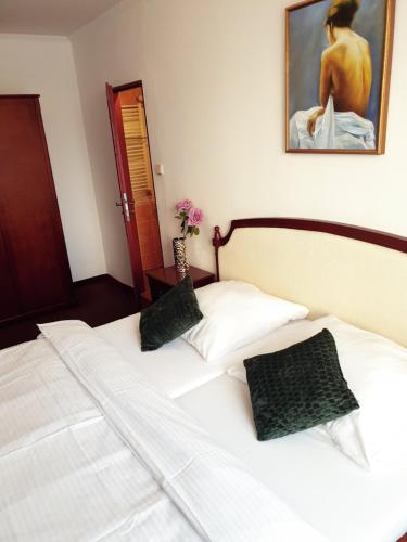 duas camas brancas num quarto com uma pintura em Wellness Hotel Haná em Mariánské Lázně