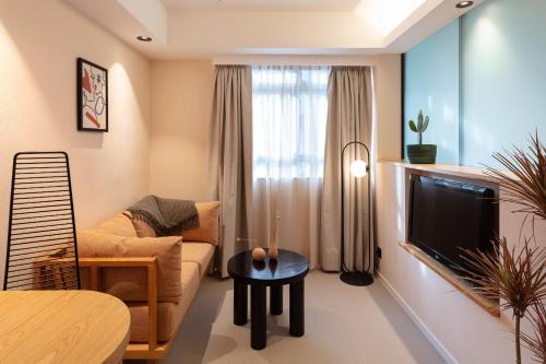 a living room with a couch and a tv at the Figo in Hong Kong