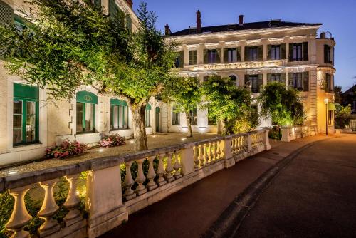 a building with a fence in front of a street at Hôtel de la Poste in Beaune