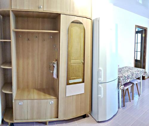 a kitchen with a refrigerator and a table and chairs at Апартаменты Нежная орхидея возле реки in Mykolaiv
