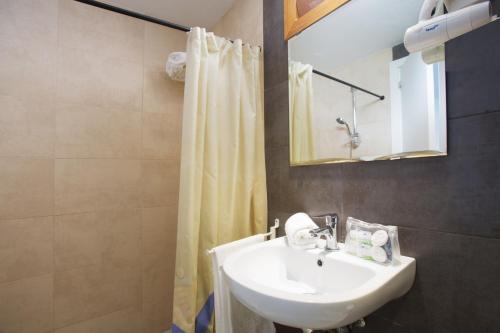 a bathroom with a sink and a shower curtain at Plazamar Serenity Resort in Santa Ponsa