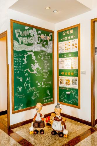 two figurines are standing in front of a chalkboard at Beachcastle & Sea View Villa in Magong