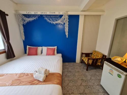 two beds in a room with a blue wall at Klai Hat Inn in Hua Hin