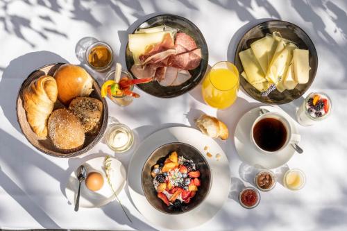 a white table with breakfast foods and coffee on it at Hotel Maier in Friedrichshafen