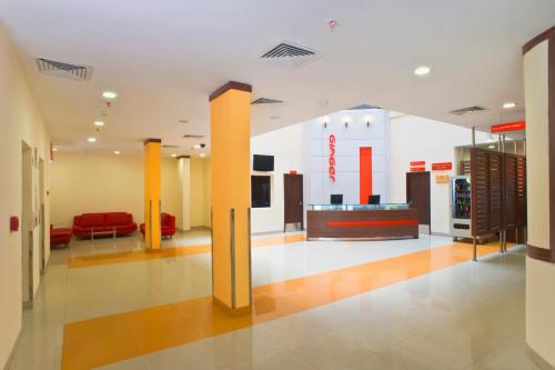 a lobby of a store with a red couch at Ginger Tirupur in Tiruppūr