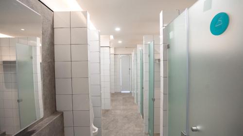 a bathroom with glass doors and tile walls at Bobopod Malioboro, Yogyakarta in Yogyakarta