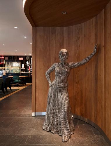 a statue of a woman in a dress on a wall at citizenM Geneva in Geneva