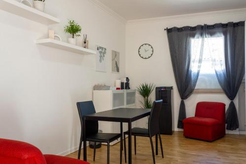 a dining room with a table and a red chair at Canton del Gallo in Padova