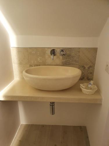 a bathroom sink with a large white bowl on a counter at Dimora del ciliegino in Fasano