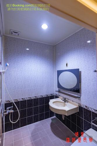 a bathroom with a sink and a mirror at Wen Sha Bao Homestay in Puli