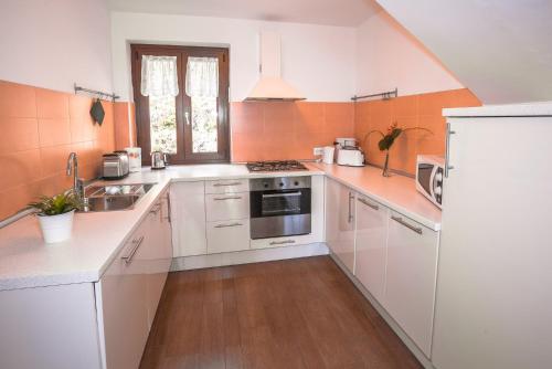 a kitchen with white cabinets and a white refrigerator at Serena Charme View in Mezzolago