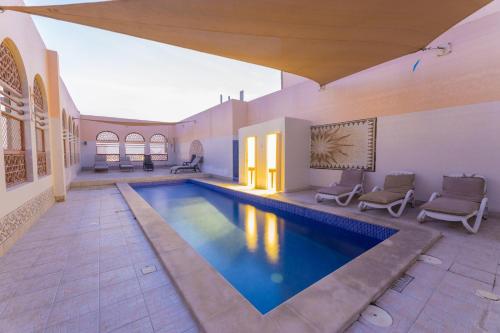 een zwembad in het midden van een huis bij Ewan Ajman Suites Hotel in Ajman 