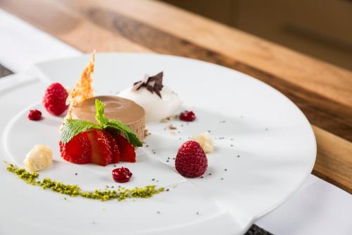 a dessert on a white plate with strawberries at voco Villach by IHG in Villach