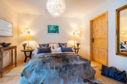 a bedroom with a large bed and a chandelier at Panorama SPA Aparthotel Schillerhof by AlpenTravel in Bad Gastein