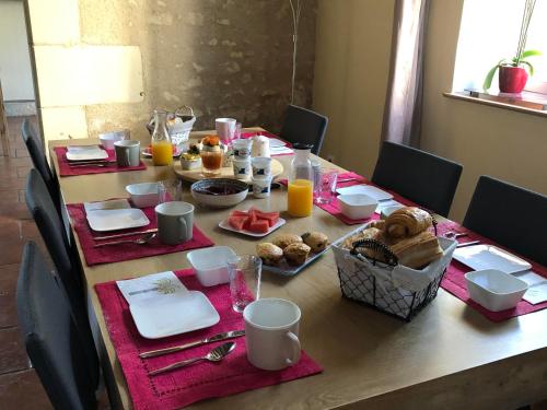 a table with breakfast foods and orange juice on it at La Tour de la Conterie in Beaumont-Village